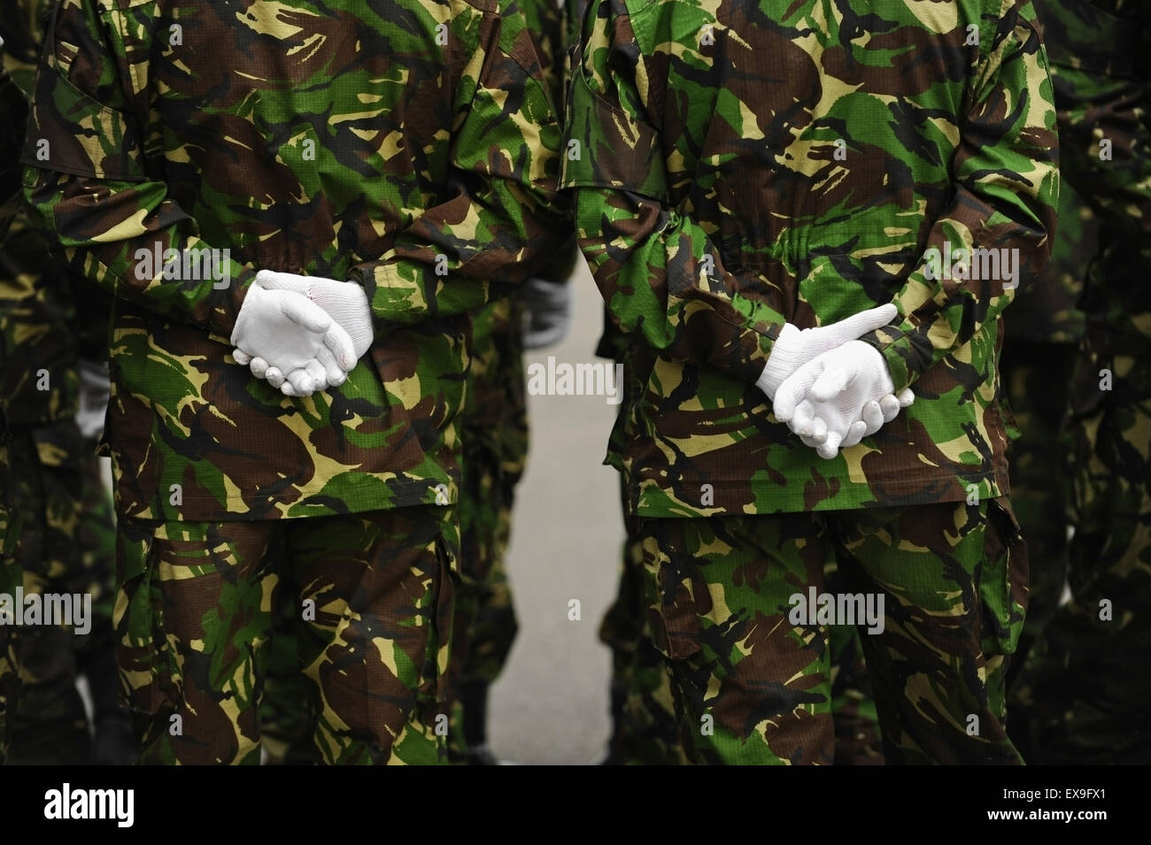 Detail shot with two soldiers in camouflage uniform with their hands on their backs Stock Photo