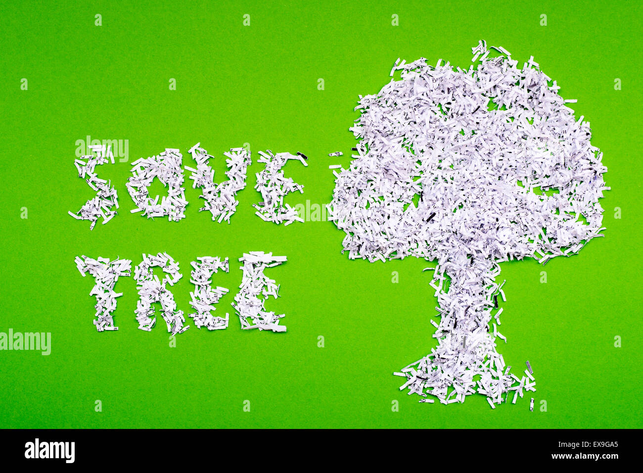 save tree concept made from shredded paper on green background ...