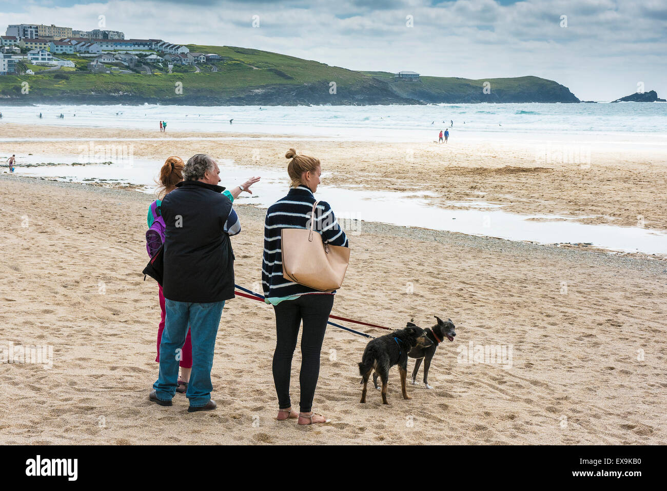 A family and their dogs standing on Fistral Beach in Newquay, Cornwall. Stock Photo