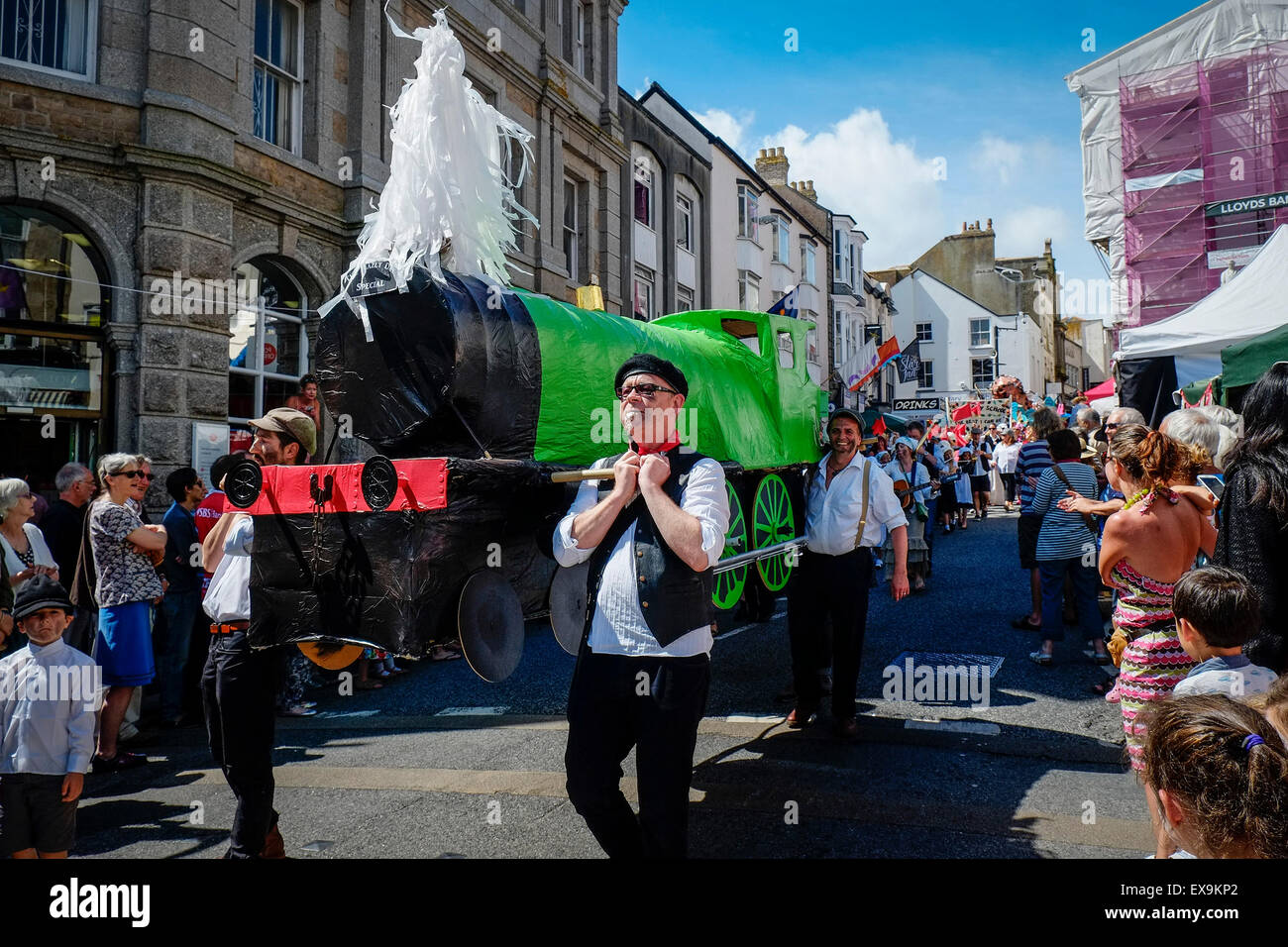 An effigy of a steam train being carried in one of the colourful parades on Mazey Day, part of the Golowan Festival in Penzance. Stock Photo