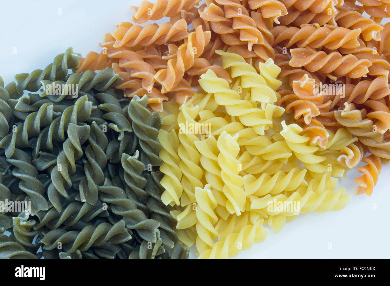 Tri-Color unprepared macaroni pasta stacked to form background Stock Photo