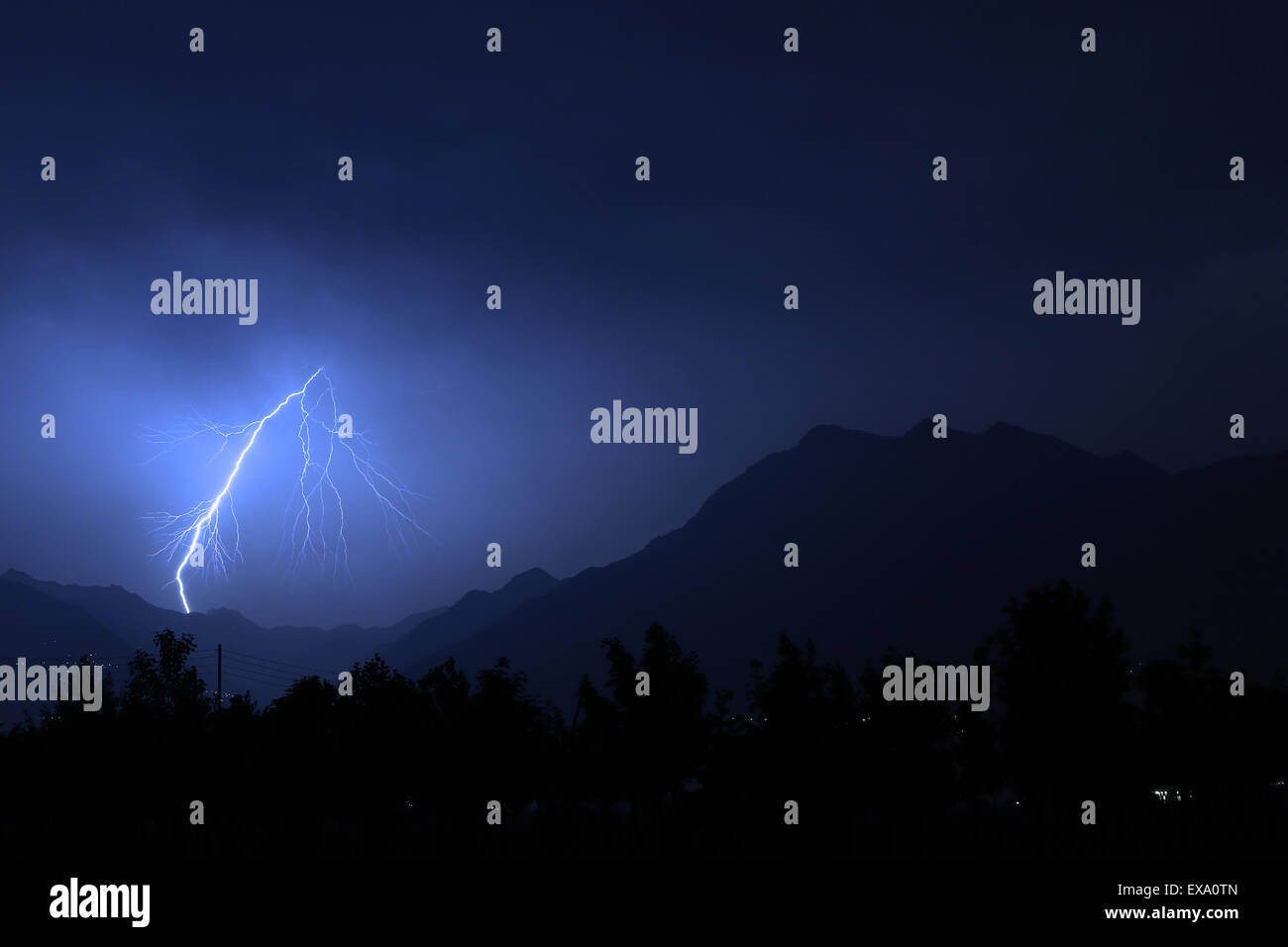 Bolt of lightning over the mountains during a summer thunderstorm Stock Photo