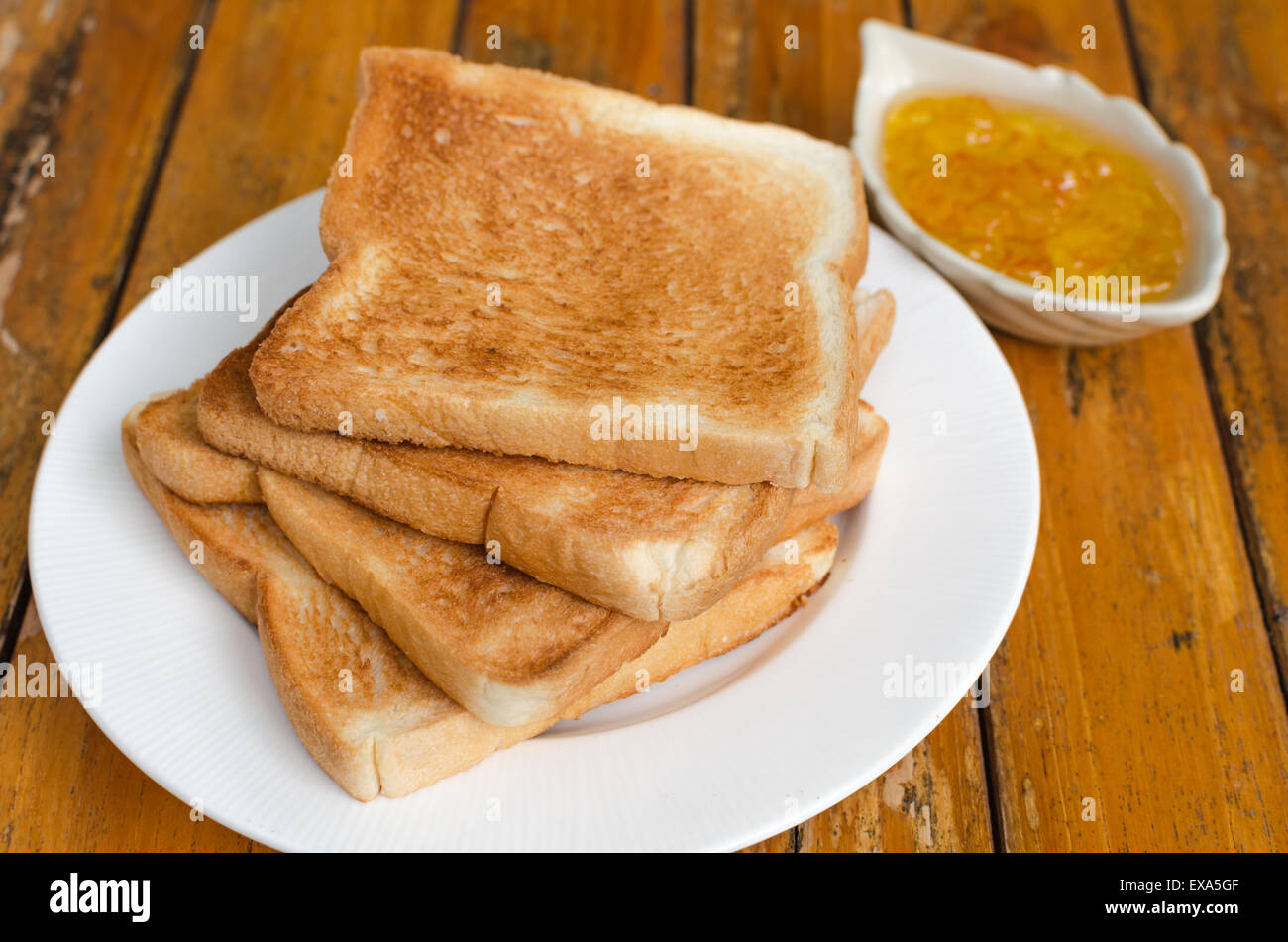 Slices of toast bread with orange jam on wood background Stock Photo