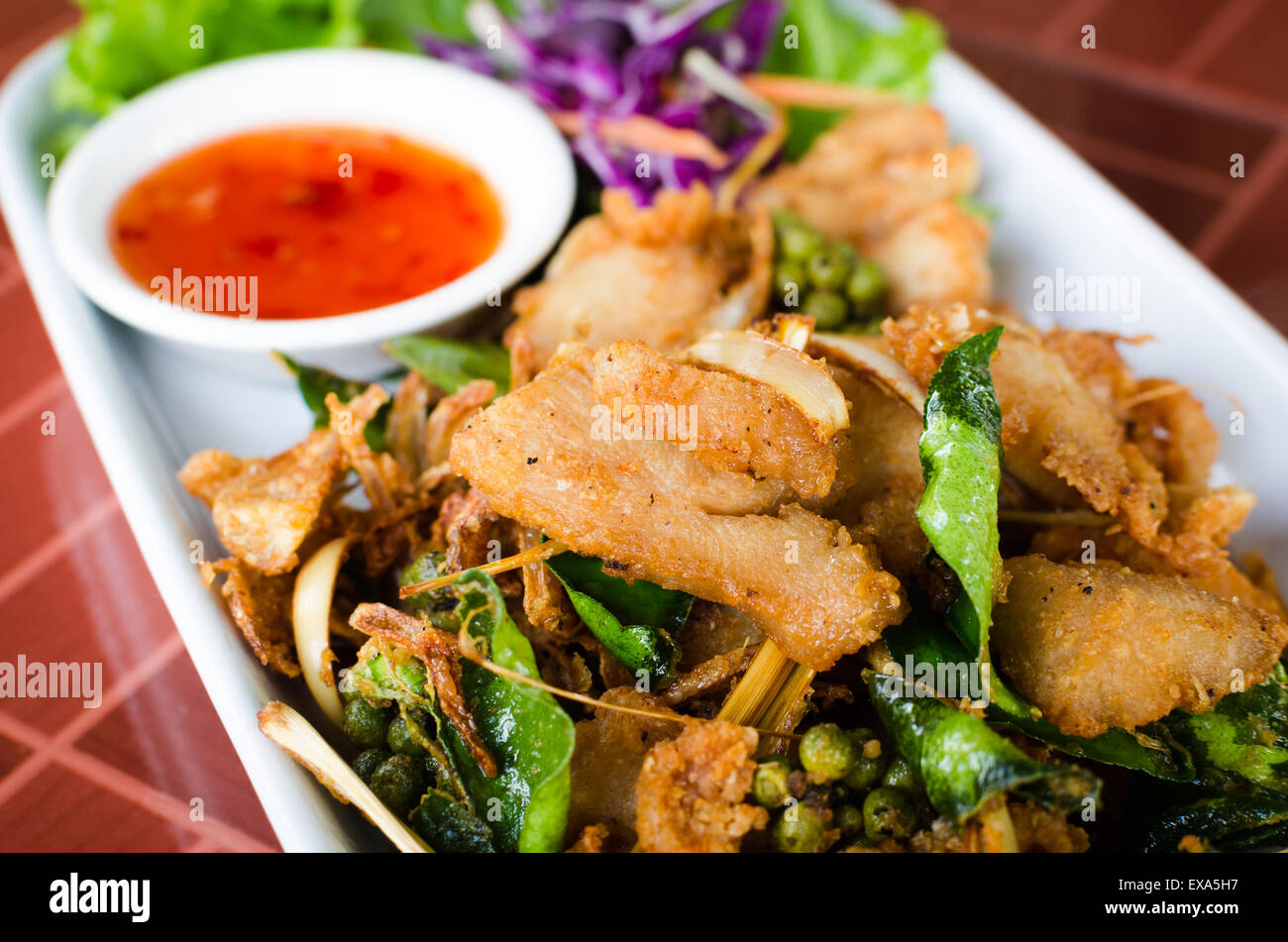 Fried Chicken with lemon grass,kaffir lime leaf,fresh pepper,garlic fried served with spicy sweet sour sauce. Stock Photo