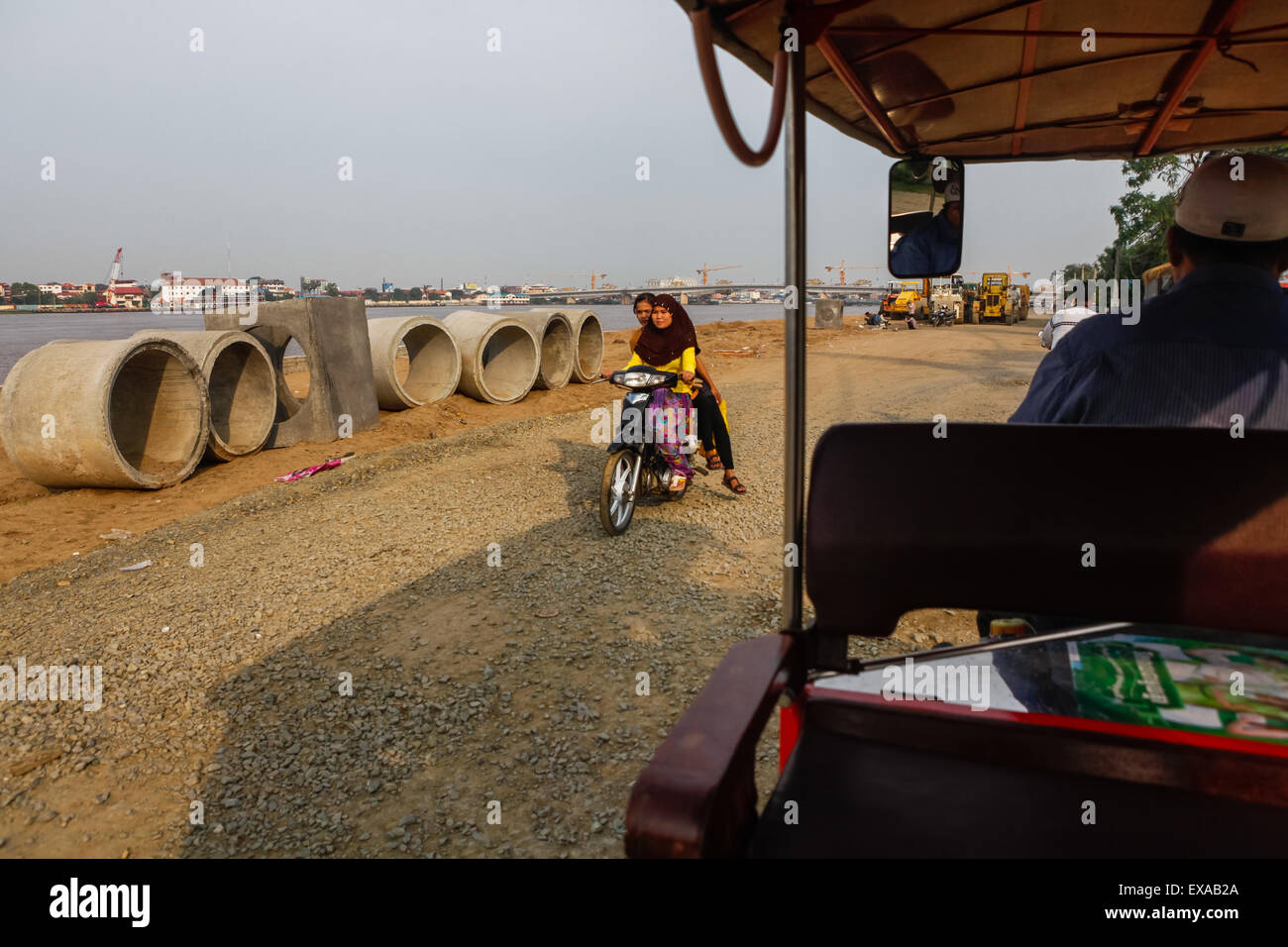 Motorists and tuk-tuk passing through an unfinished road construction project on the side of Tonle Sap river in Phnom Penh, Cambodia. Stock Photo