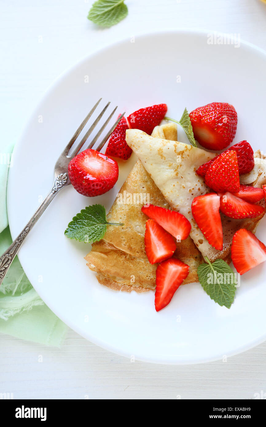 crepes with slices of strawberries on plate Stock Photo