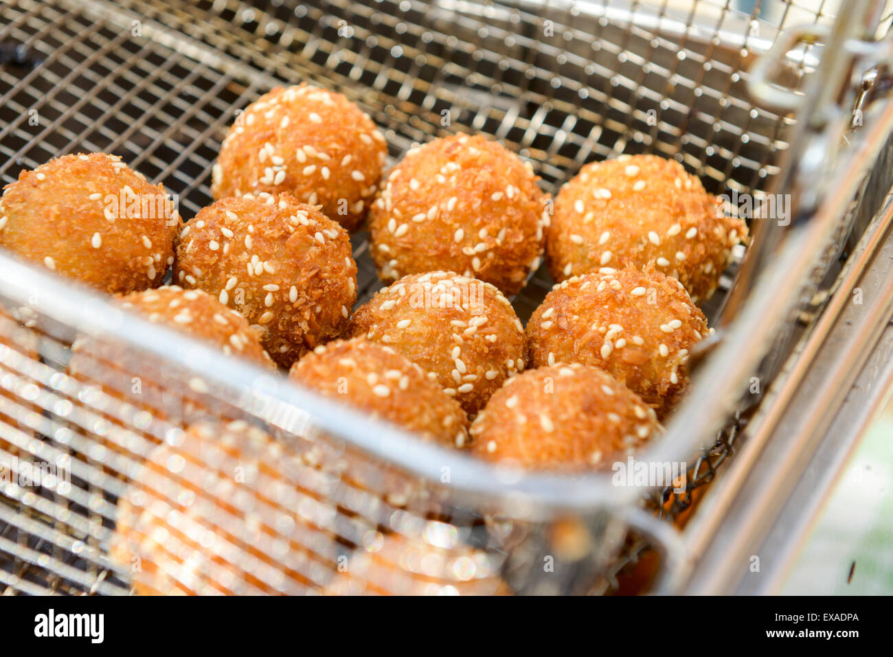 ruddy crispy cheese balls with spices in a metal grid Stock Photo