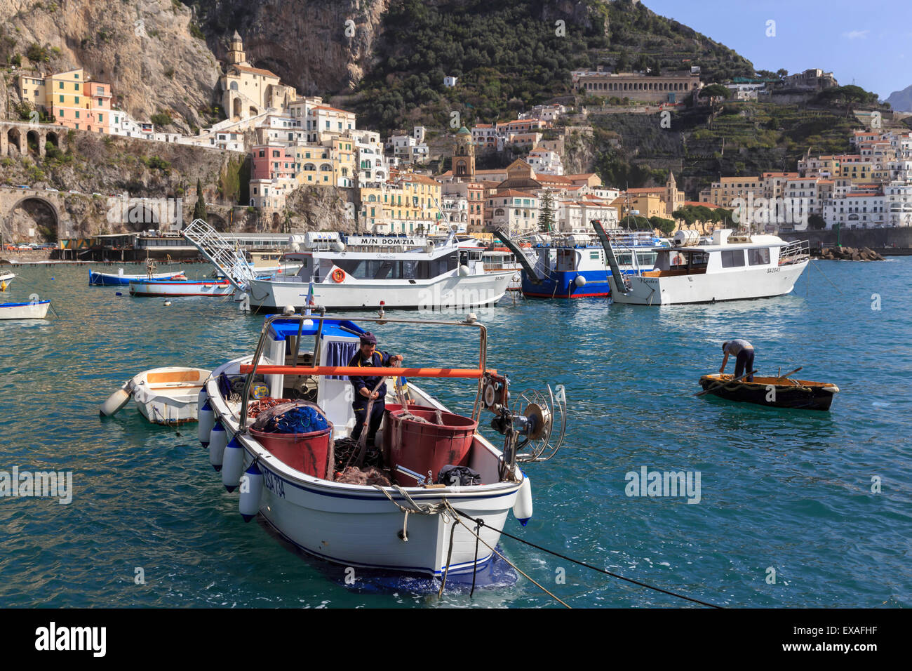 Fisherman in fishing boat in Amalfi harbour, from quayside with view