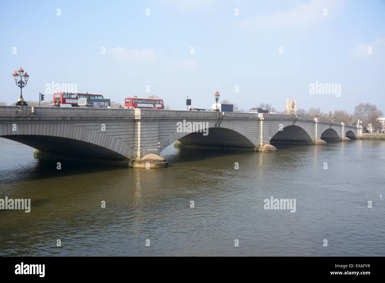 Busses and cars cross Putney Bridge the south bank of the River Thames Stock Photo