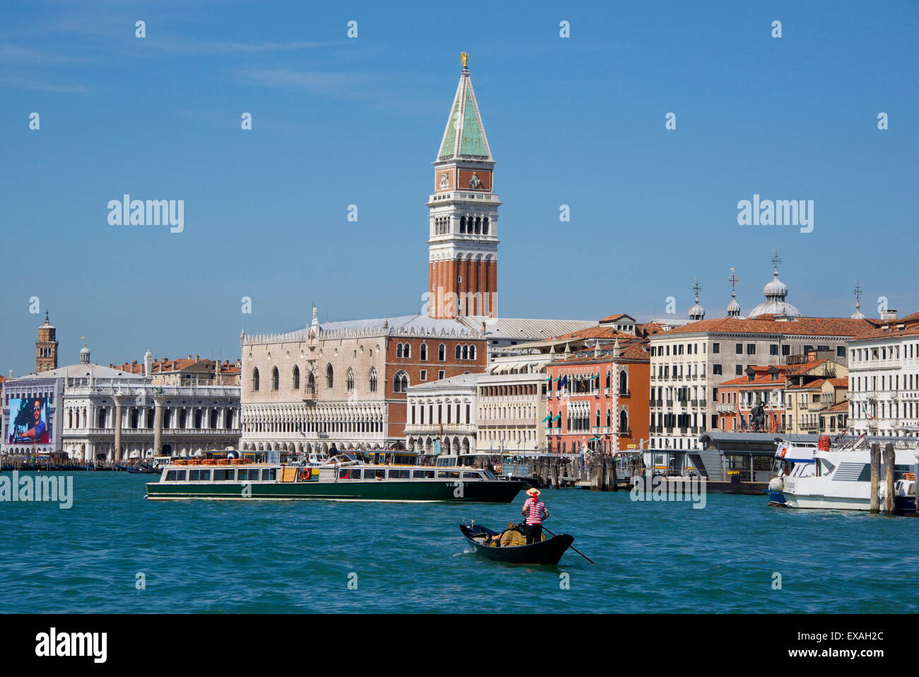 Gondola and gondolier on San Marco Basin, with Palazzo Ducale, San Marco Campanile, Venice, Veneto, Italy Stock Photo