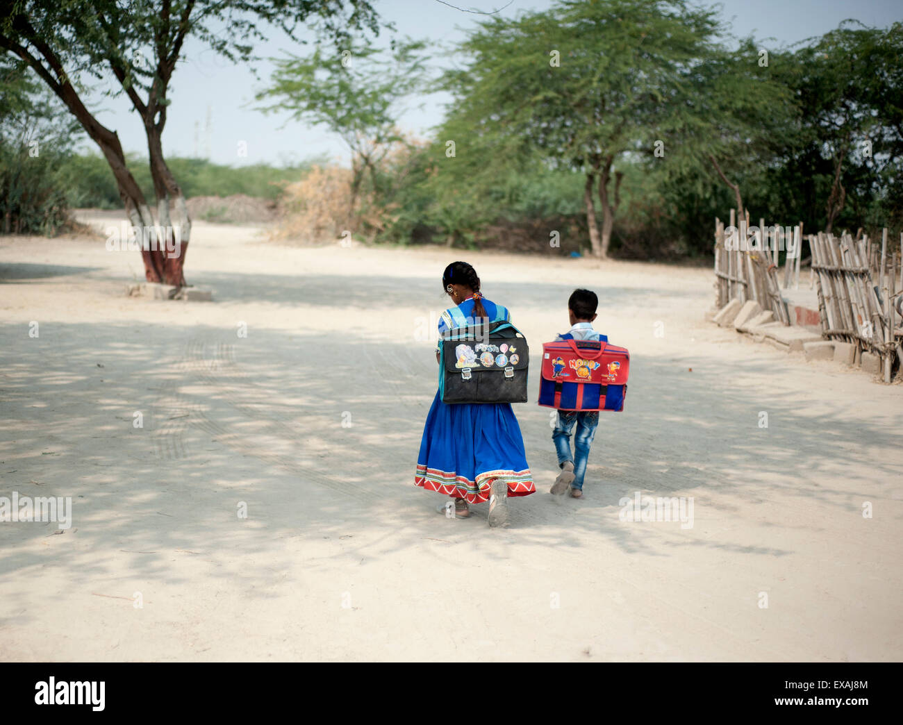 Young boy, and girl in Gujarati skirt, with satchels, walking to school, Bhirindiara, Kachchh (Kutch), Gujarat, India, Asia Stock Photo