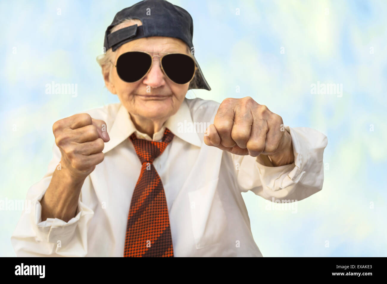 Funny elderly woman wearing cap in a fight pose. Selective focus. Stock Photo