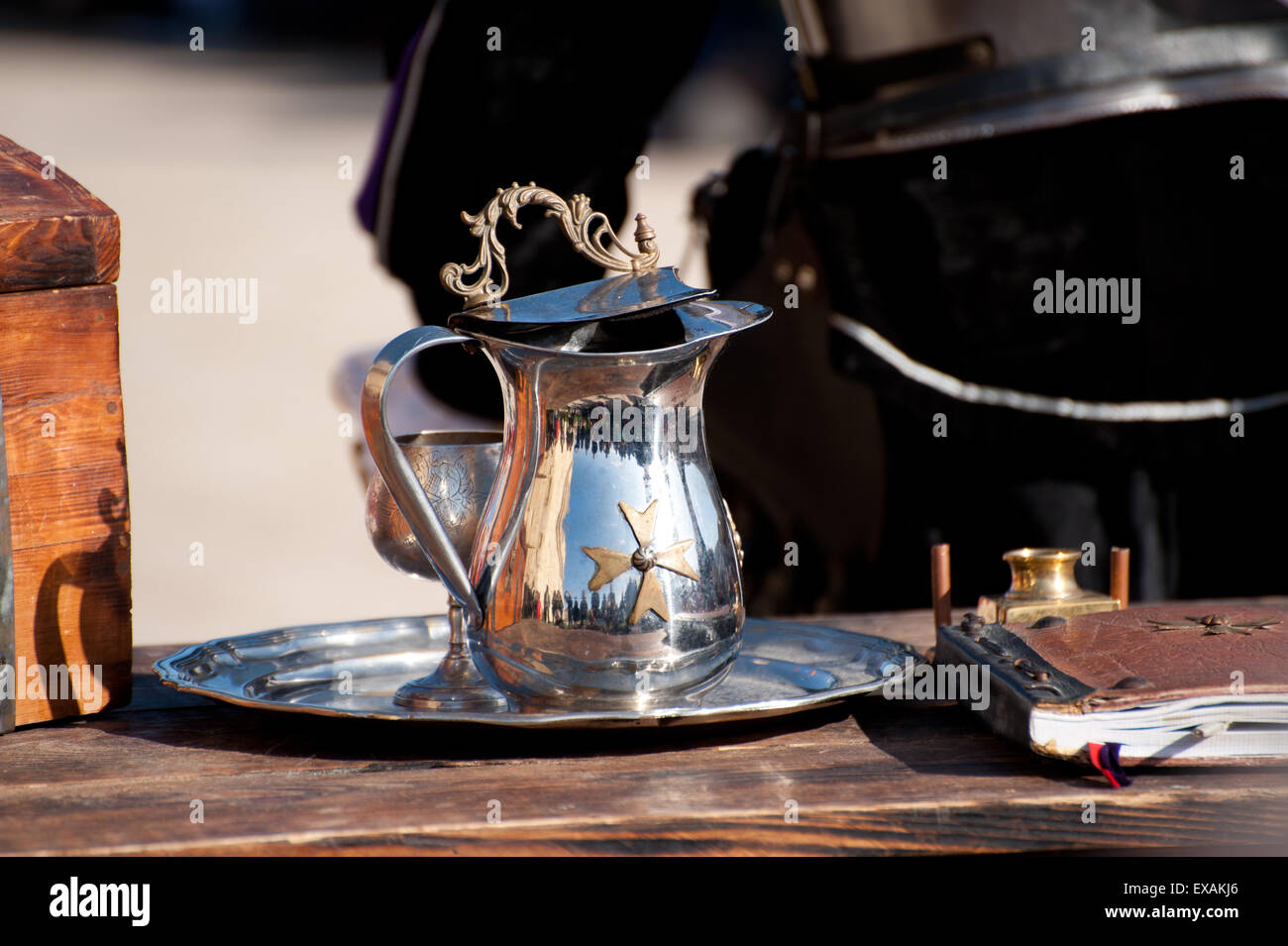 A Metal pitcher with Maltese cross stay on the table Stock Photo