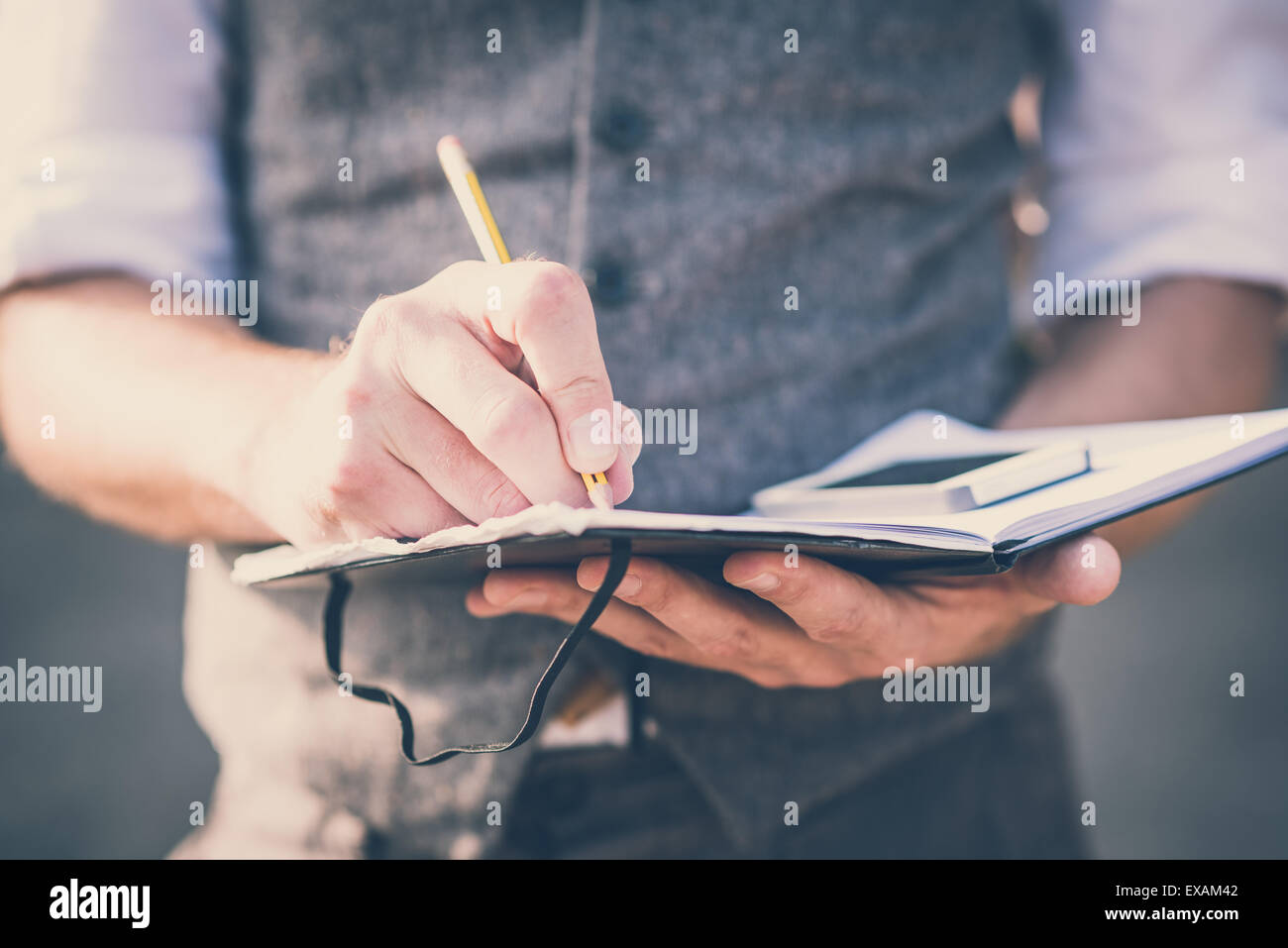 close up hands man writing on diary and smartphone outdoor Stock Photo ...