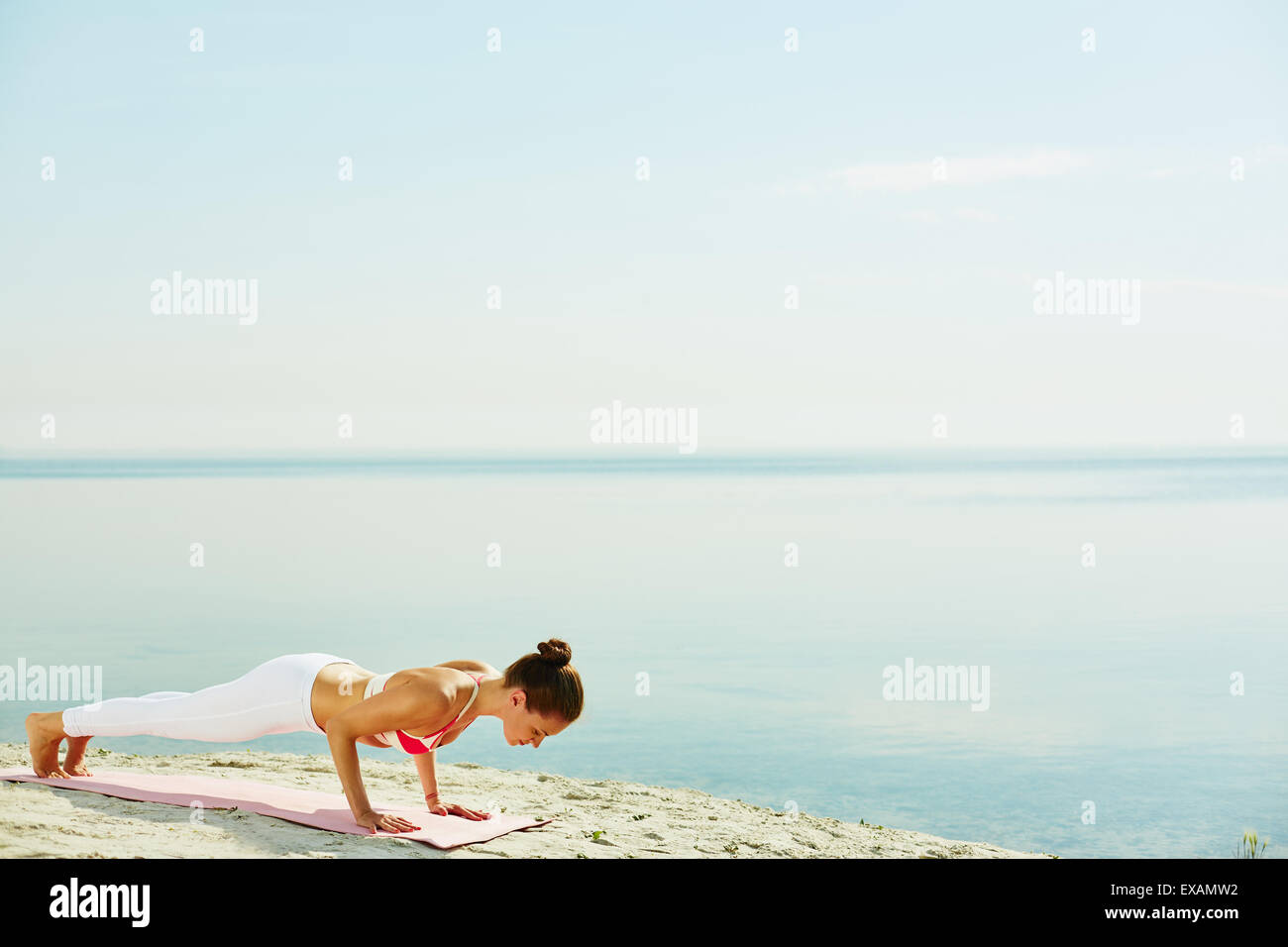 Fit woman doing pushups by the seaside Stock Photo