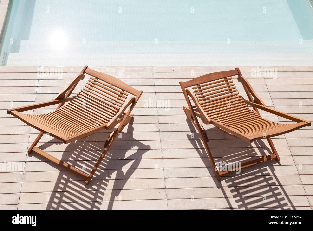 Wooden deck chairs beside pool Stock Photo Alamy
