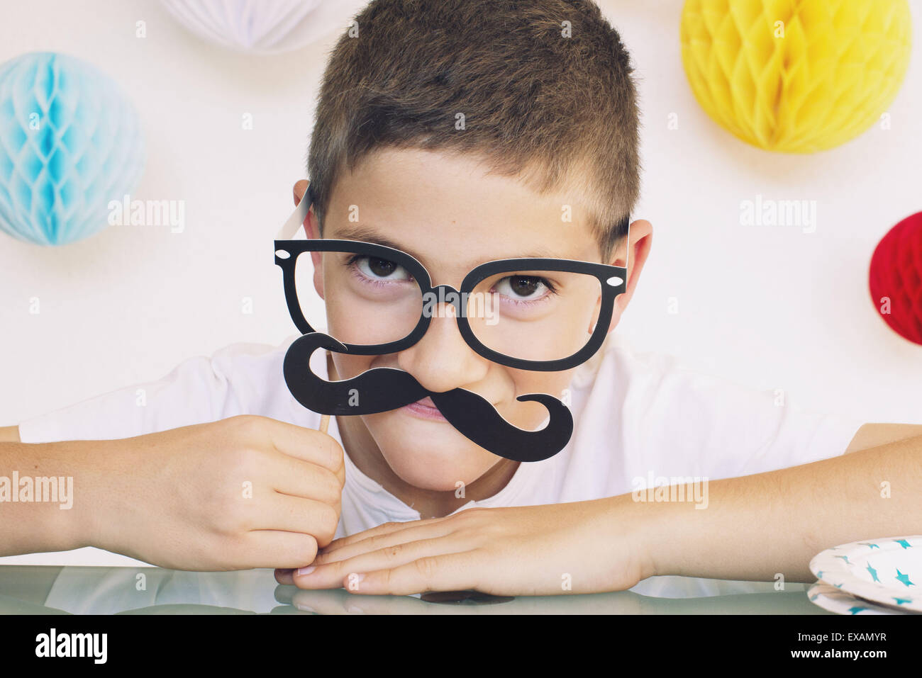 Boy wearing fake mustache and glasses at a birthday party Stock Photo