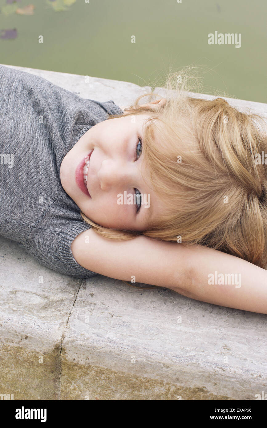 Little girl lying beside pond, portrait Stock Photo