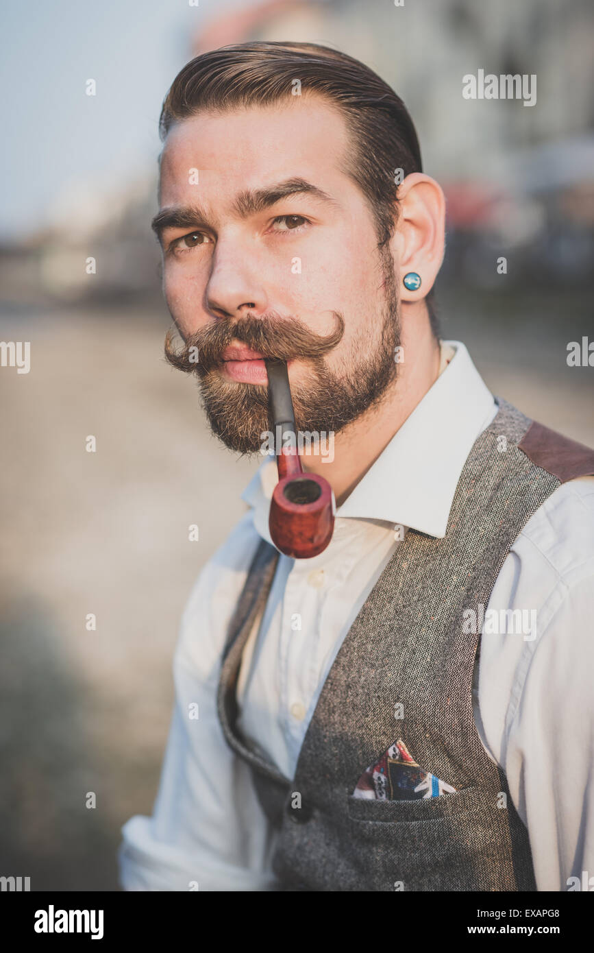handsome big moustache hipster man smoking pipe in the city Stock ...