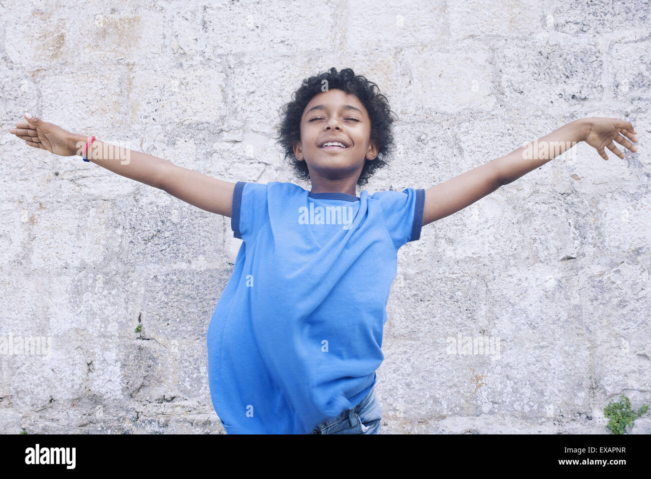 Boy standing with his arms outstretched, eyes closed, portrait Stock Photo