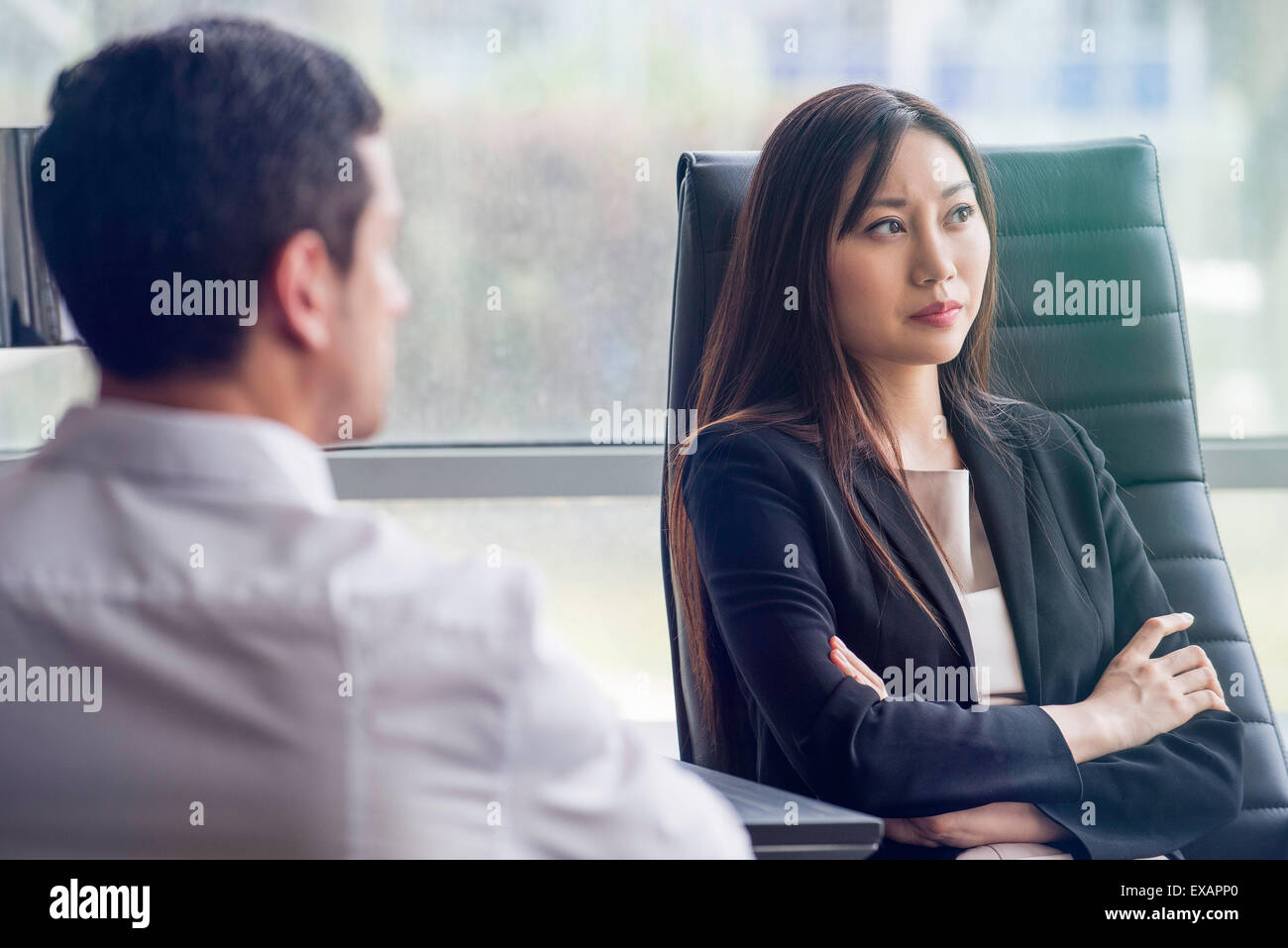 Business woman with arms folded looking away with air of disappointment Stock Photo