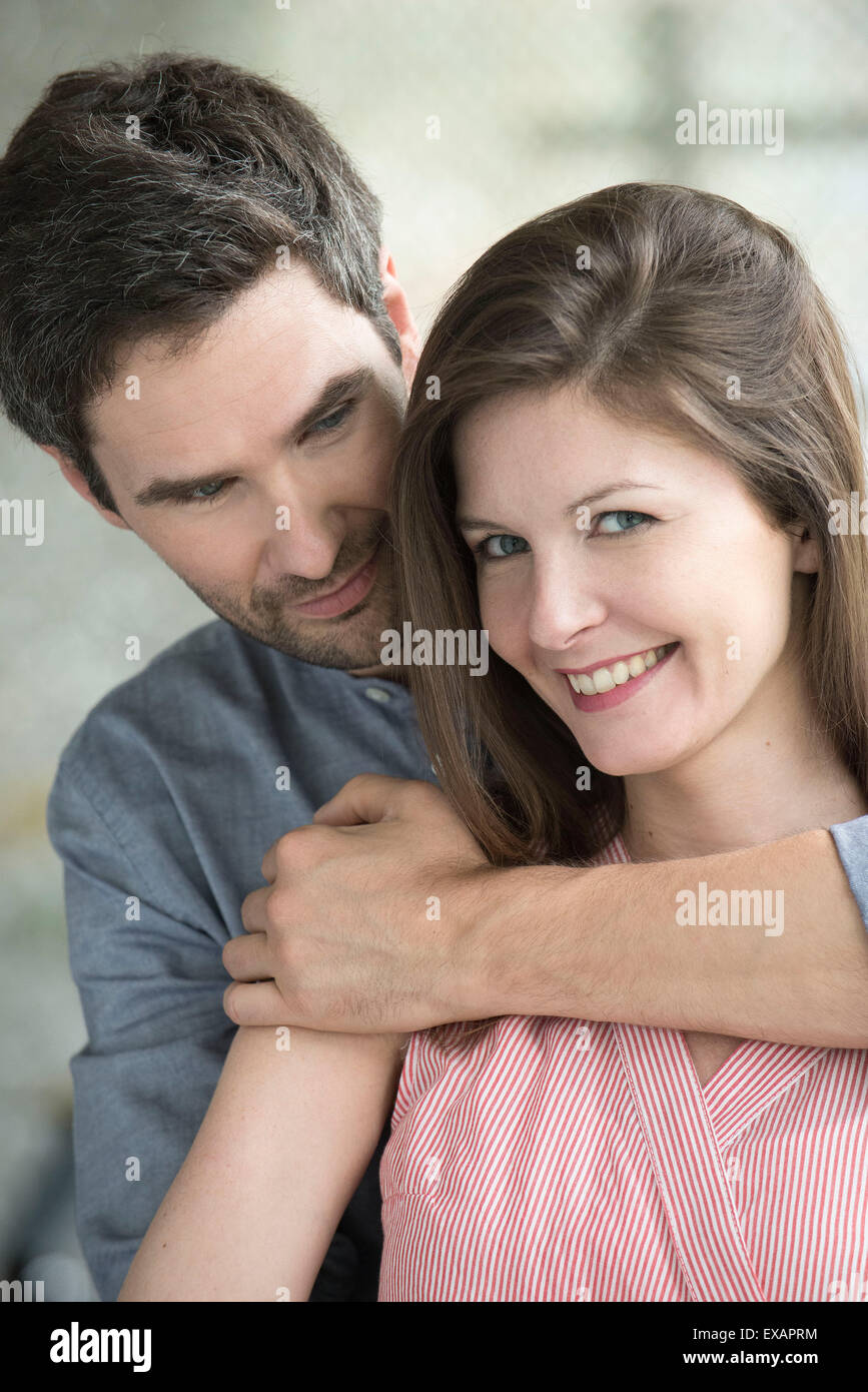 Woman smiling as husband embraces her, portrait Stock Photo