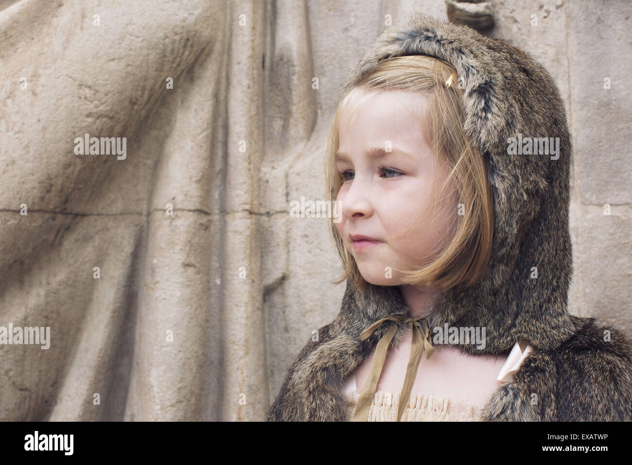 Little girl wearing hooded fur cloak outdoors, portrait Stock Photo
