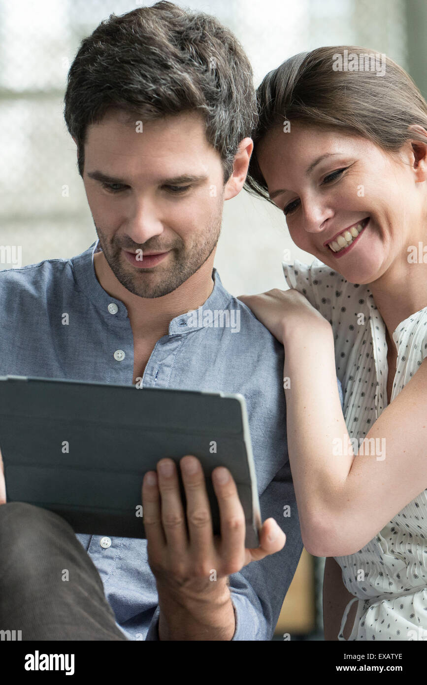 Couple using digital tablet together at home Stock Photo - Alamy
