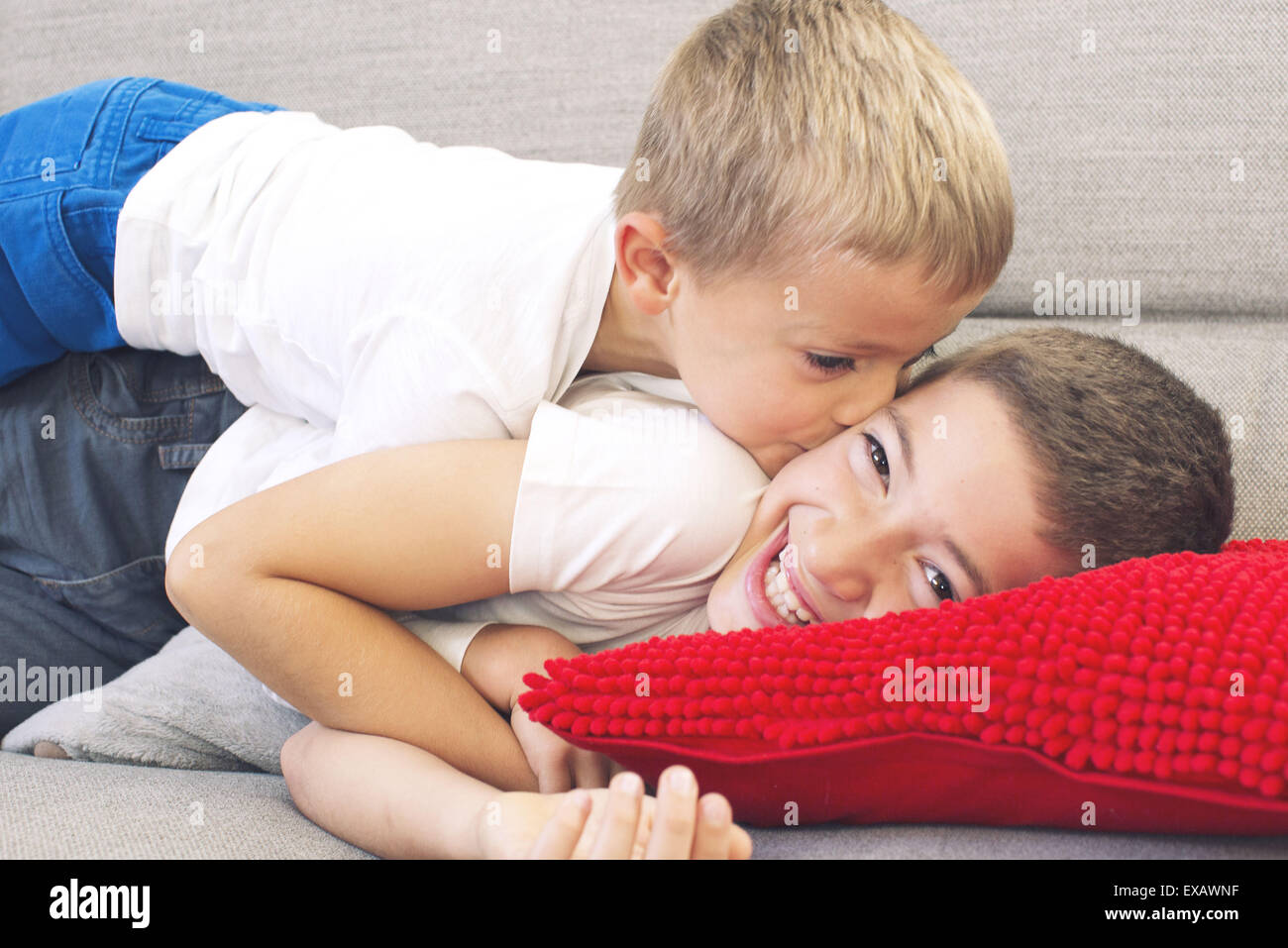 Little boy kissing his older brother's cheek Stock Photo