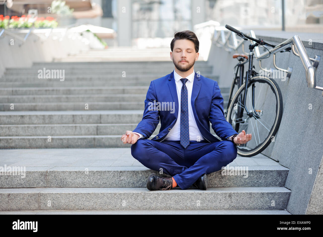 Young businessman practicing yoga on stairs Stock Photo - Alamy
