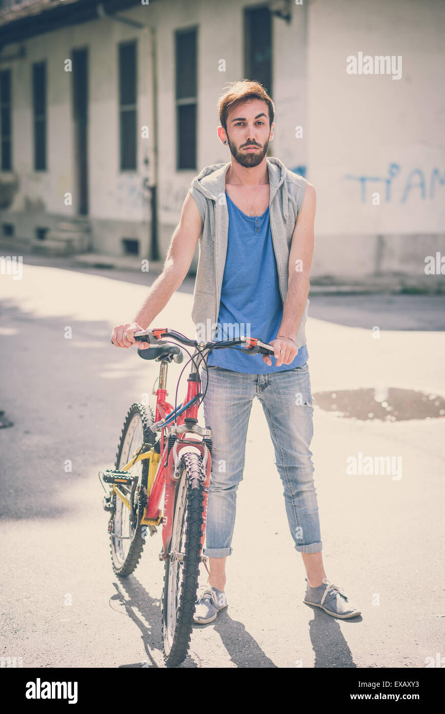 young hipster gay man with bike in the city Stock Photo
