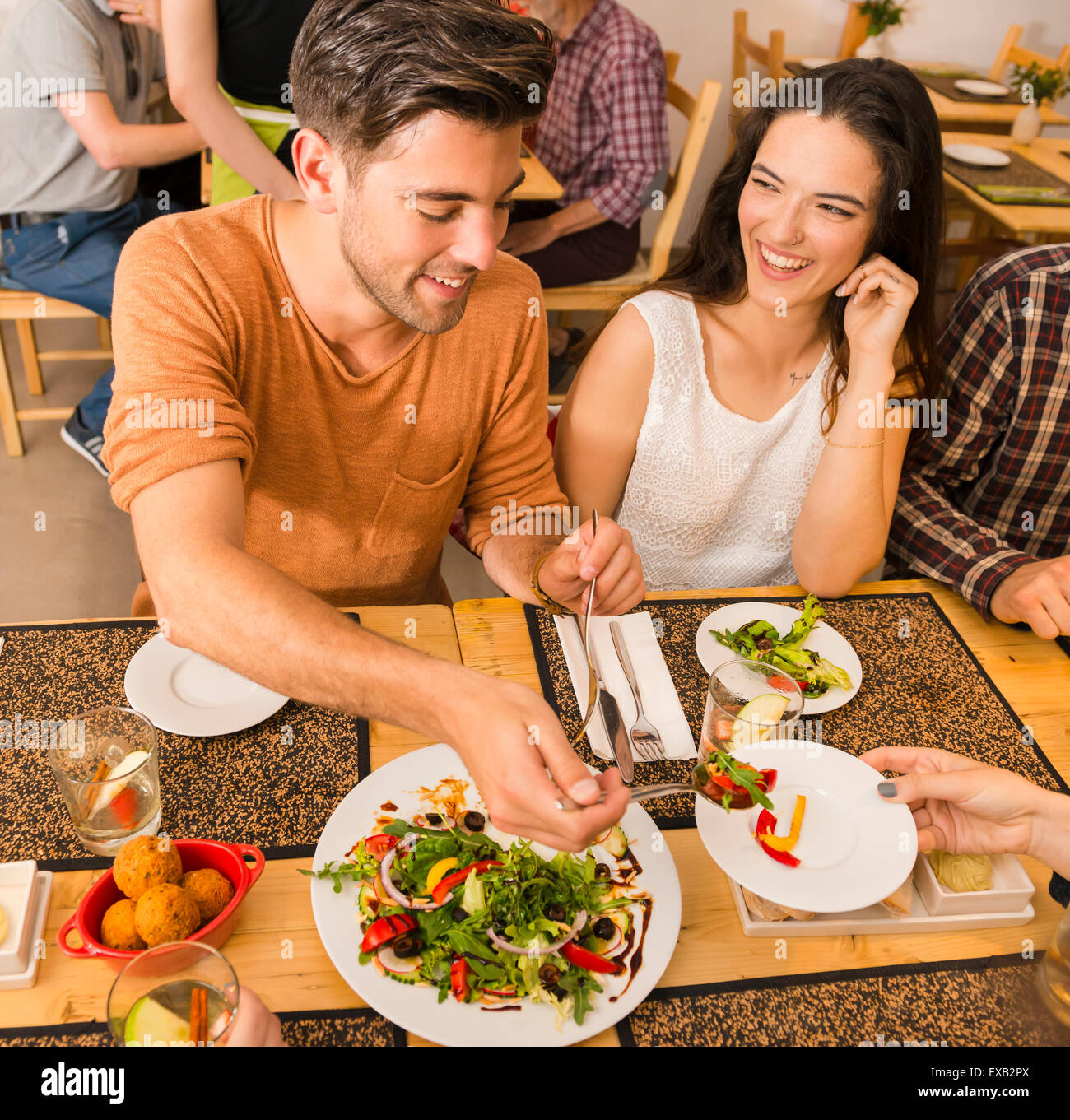 Happy couple at the restaurant and being served of food in the plate Stock Photo