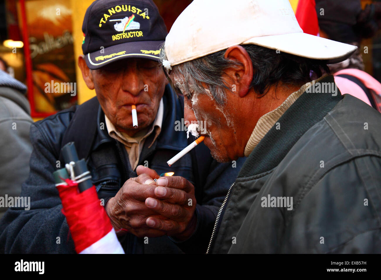 La Paz, Bolivia, 10th July 2015. Protesters from Potosi smoke cigarettes and use tissue paper in their nostrils to combat the effects of tear gas during a protest by the Potosi Civic Committee and supporters. They are in La Paz to demand the government keeps promises made to the region in the past, which include the construction of a cement factory, hospitals, a hydroelectric plant and an international airport. Police used tear gas to prevent the protesters entering Plaza Murillo Credit:  James Brunker / Alamy Live News Stock Photo