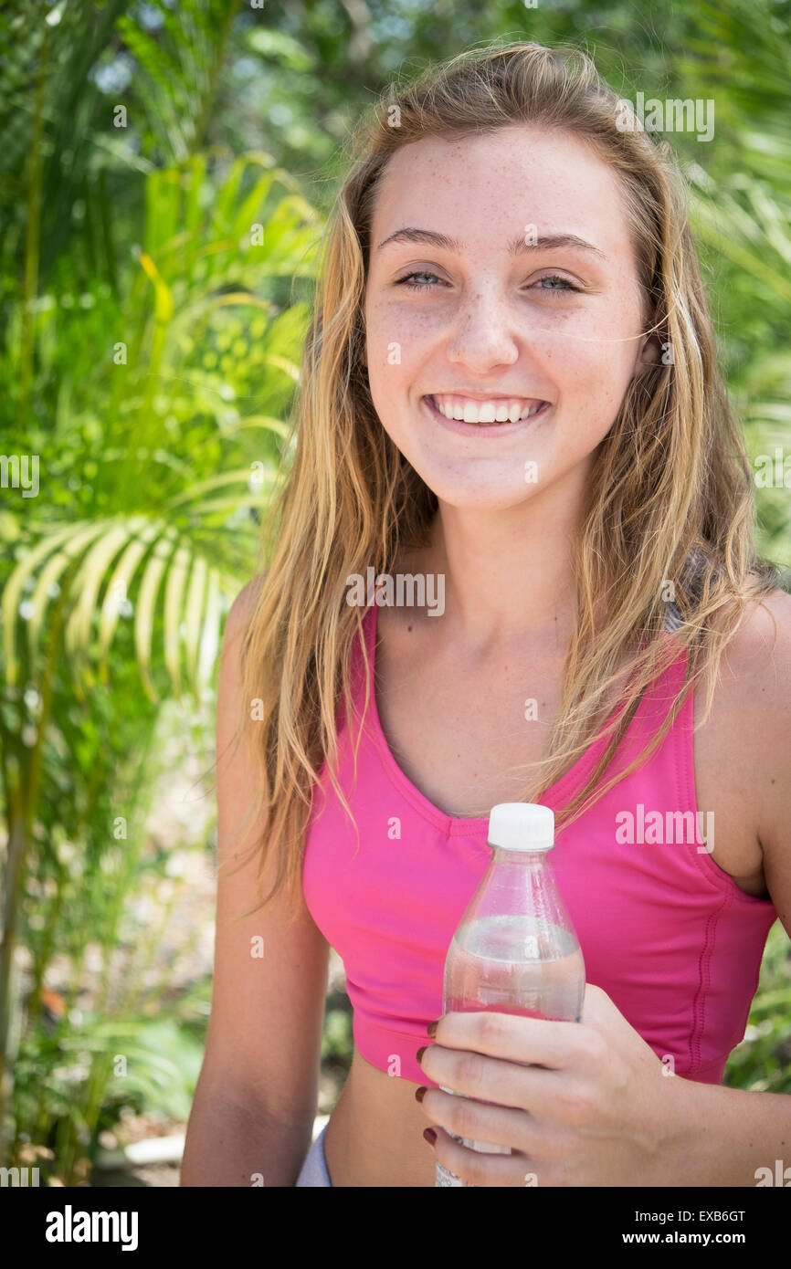 Young girl laughing while holding water bottle. Female teenager, 13 years, Nayarit, Mexico Stock Photo