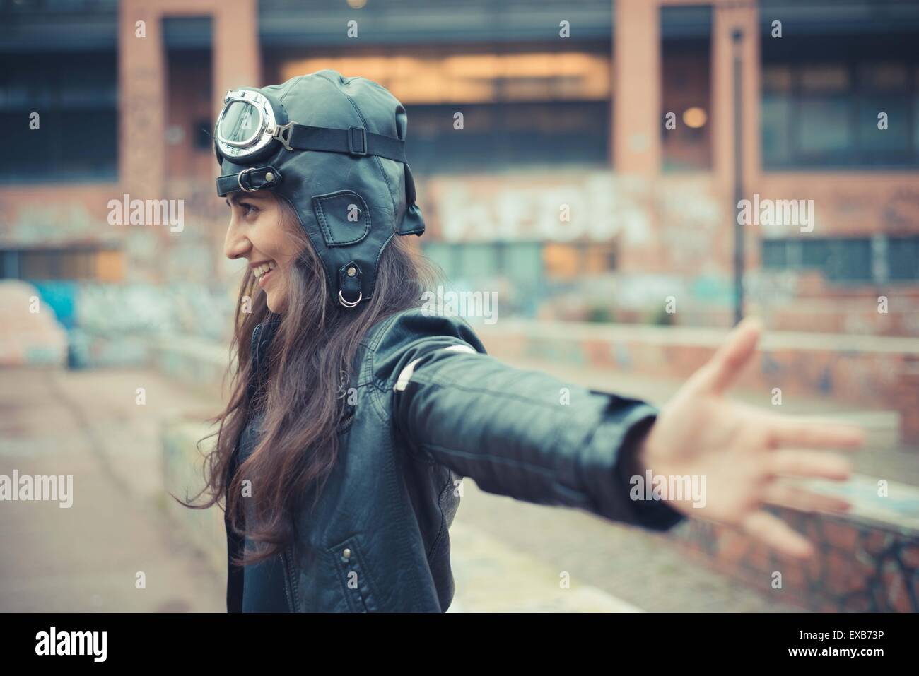 aviator young beautiful brunette woman with cap and glasses in the city Stock Photo