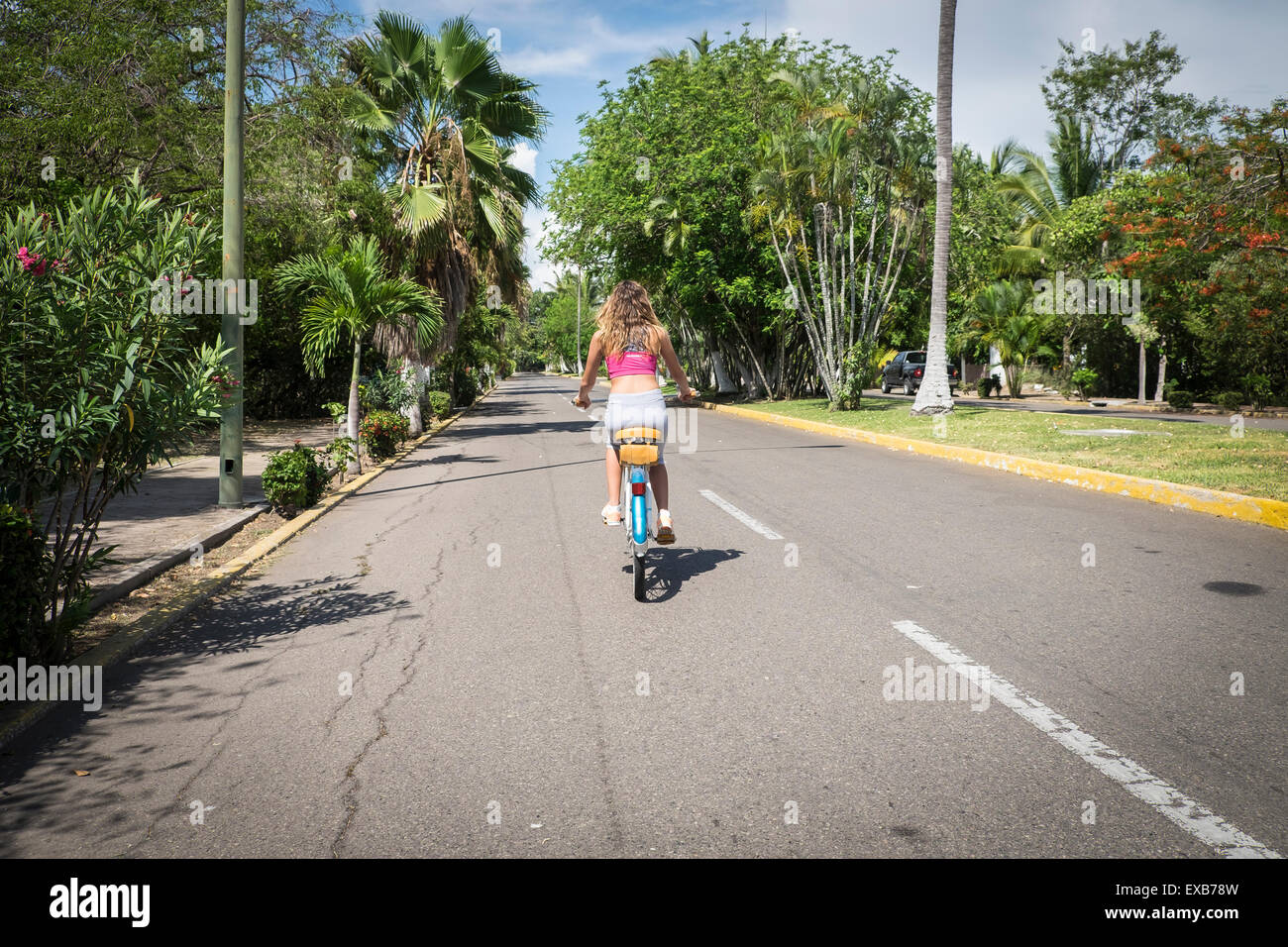 Back view of girl riding bicycle. Female teenager, 13 years, Nayarit, Mexico Stock Photo