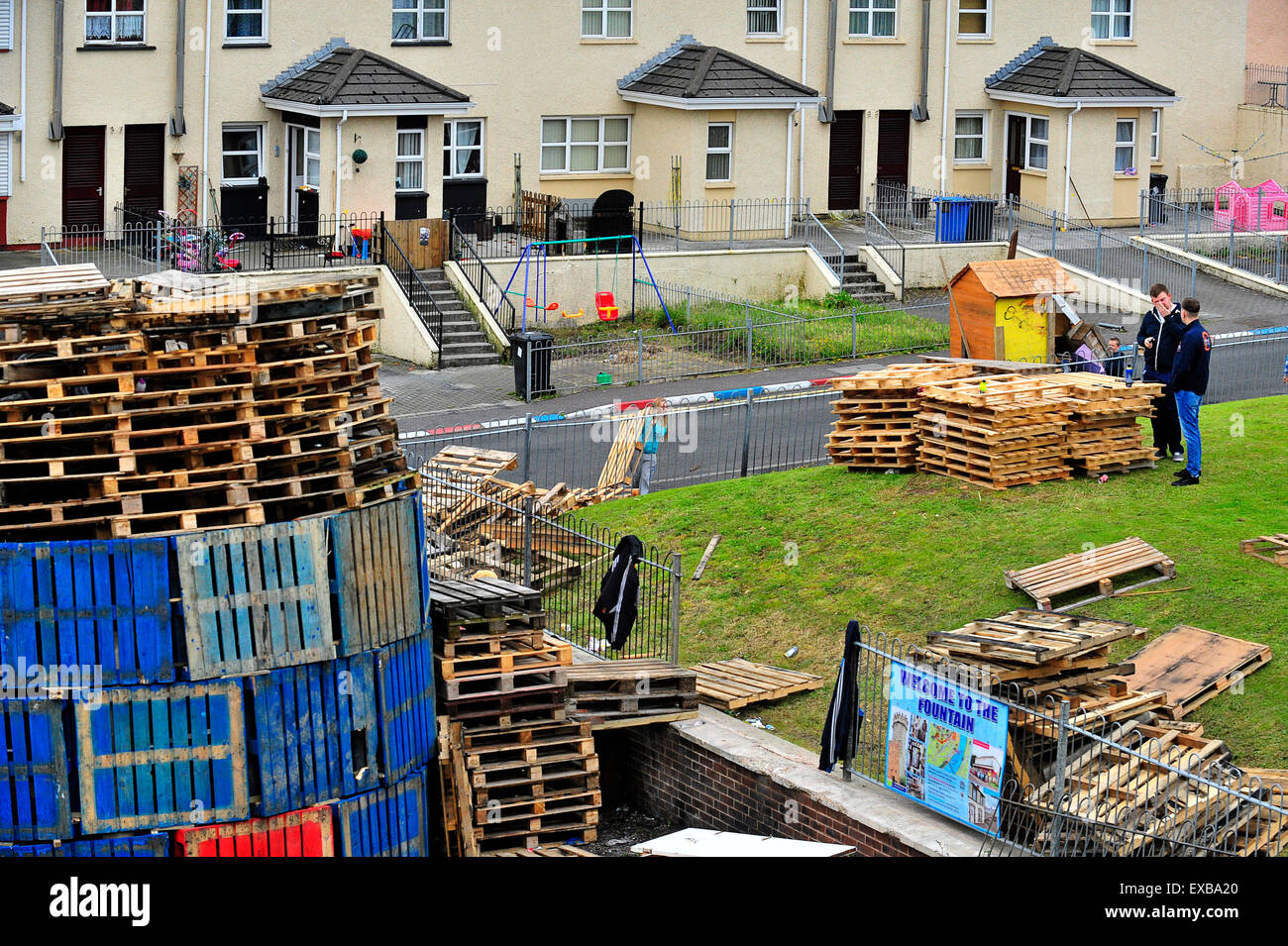 Londonderry, Northern Ireland, UK. 10th July, 2015. Bonfires constructed ahead of Annual Orange Order Parades, Londonderry, Northern Ireland – 10 July 2015. Loyalists in the Fountain Estate construct an 11th night bonfire, with pallets and tyres, to be set  alight  ahead of the annual “Twelfth” of July Orange Order Parades. The 12th July commemorates the in 1690 when Protestant King William III defeated the exiled Catholic King James II. © George Sweeney/Alamy Live News Credit:  George Sweeney/Alamy Live News Stock Photo