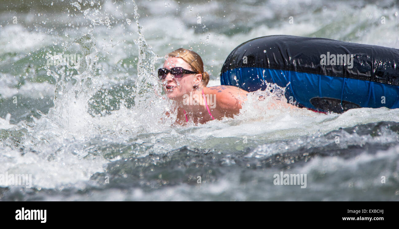 Floating the Boise River. Woman with tube swimming in churning rapids. Boise, Idaho, USA Stock Photo