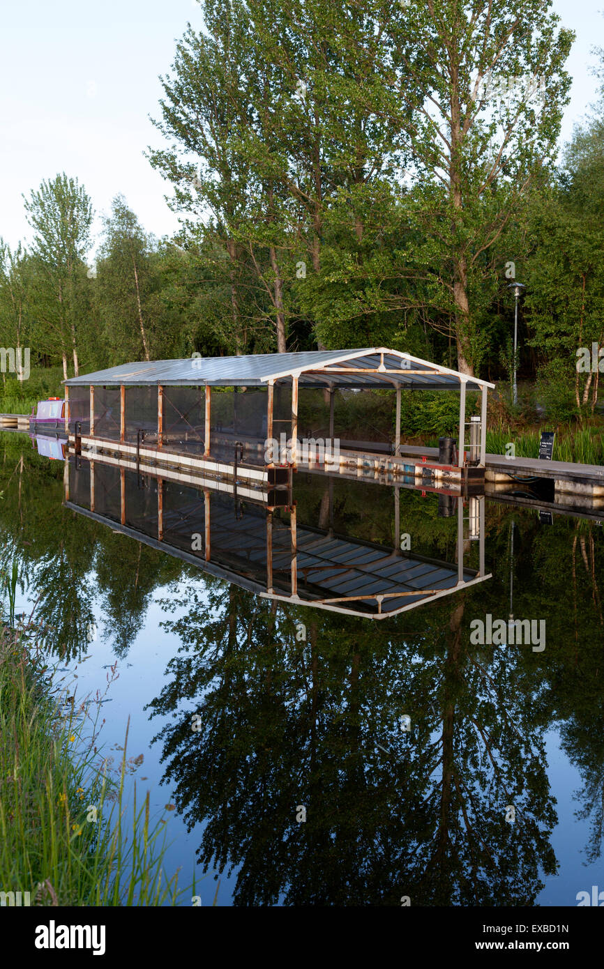 Boat shed reflecting evening light in the canal, Falkirk, Stirling Stock Photo