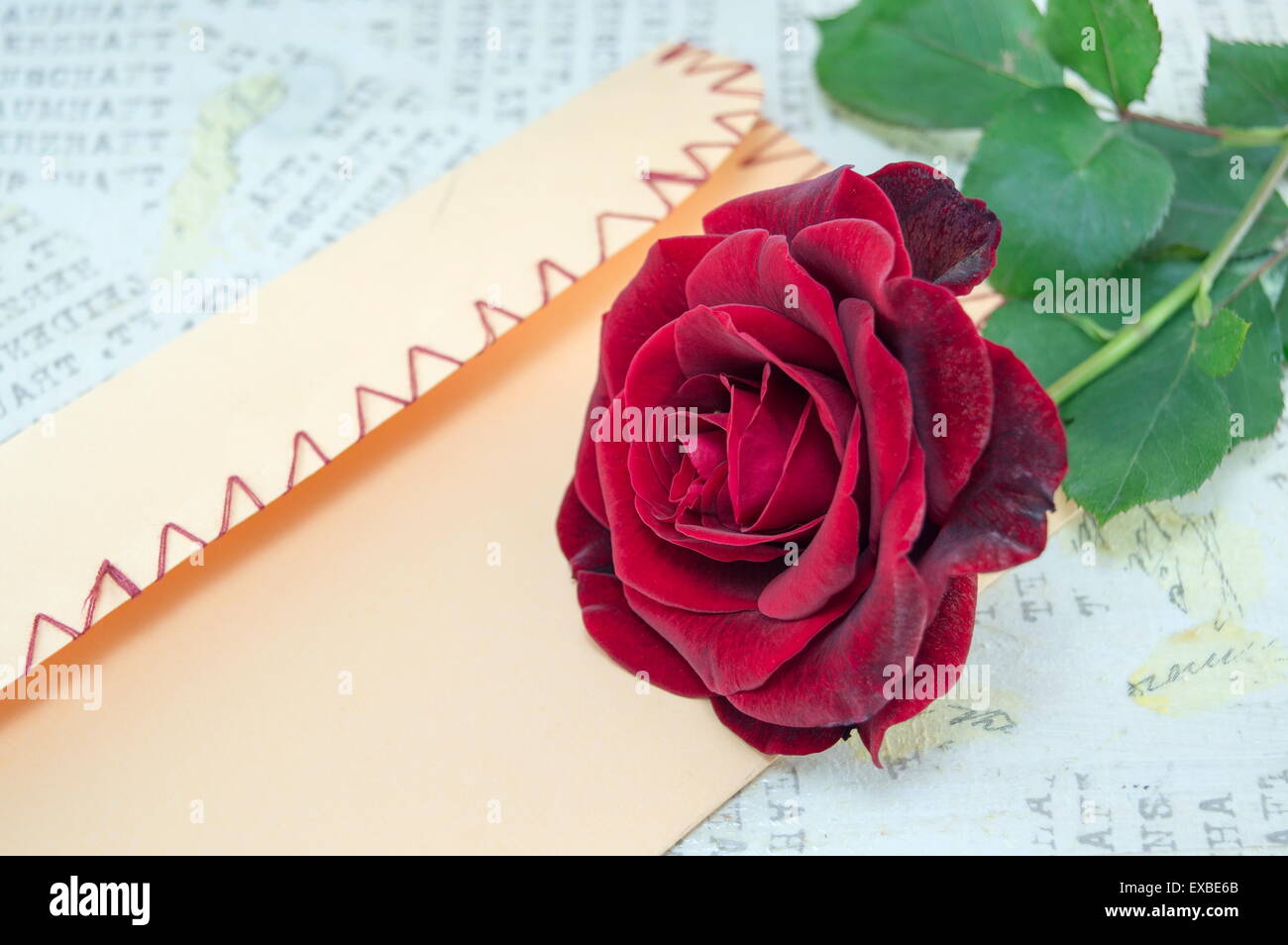 Rose and a handmade love letter on a table decorated with hearts Stock Photo