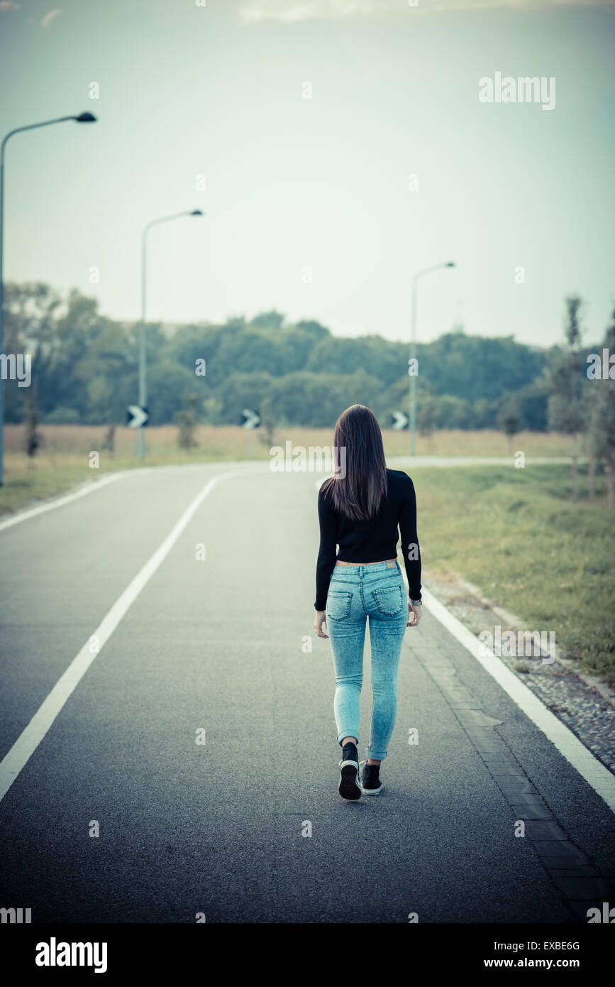 Young woman walking empty road hi-res stock photography and images - Alamy