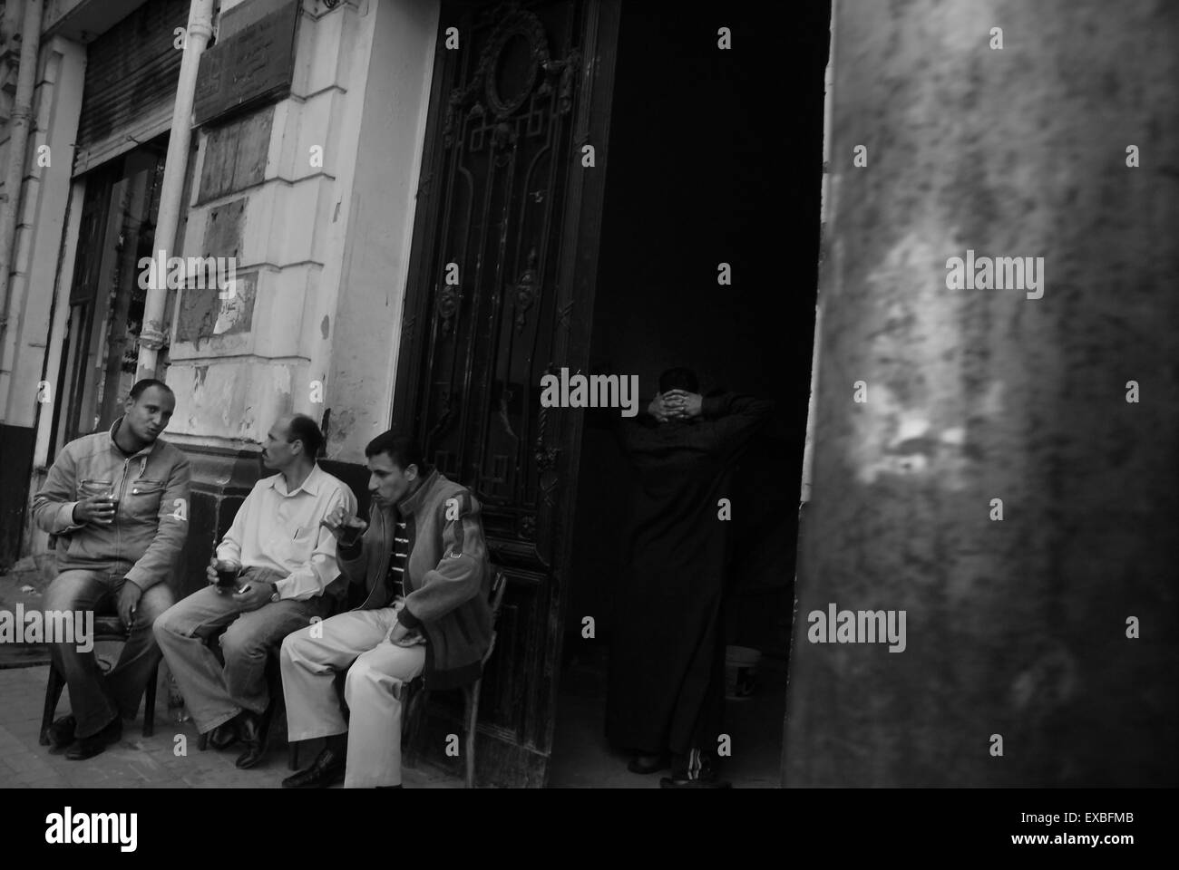 Three men drinking coffee in a Cairo backstreet Stock Photo