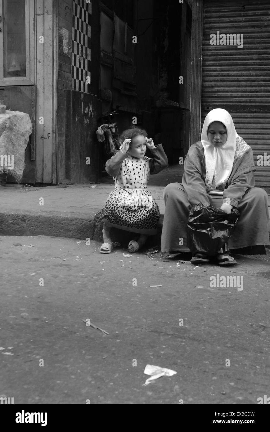 Mother and child sitting by road, Cairo, Egypt Stock Photo