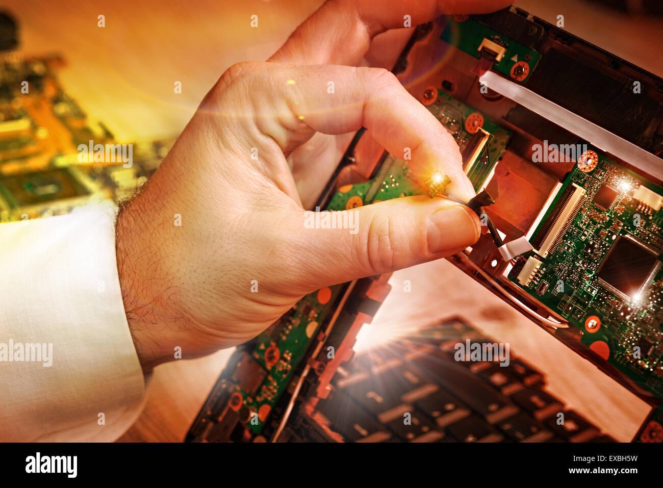 Tech fixes laptop motherboard in service center. Shallow DOF, focus on ...