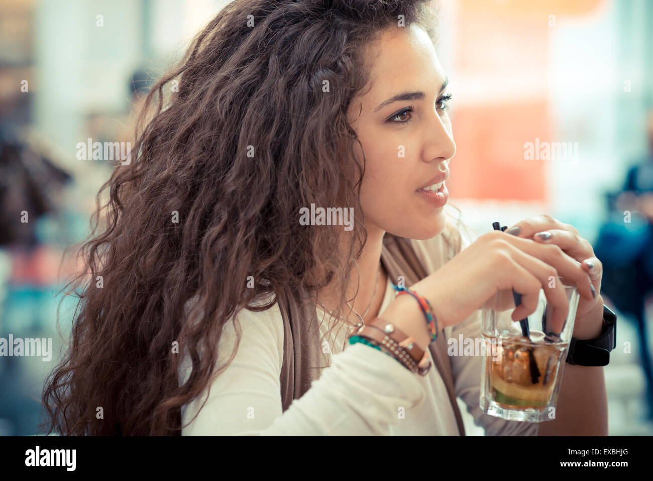 beautiful curly long brunette hair moroccan woman with cocktail at
