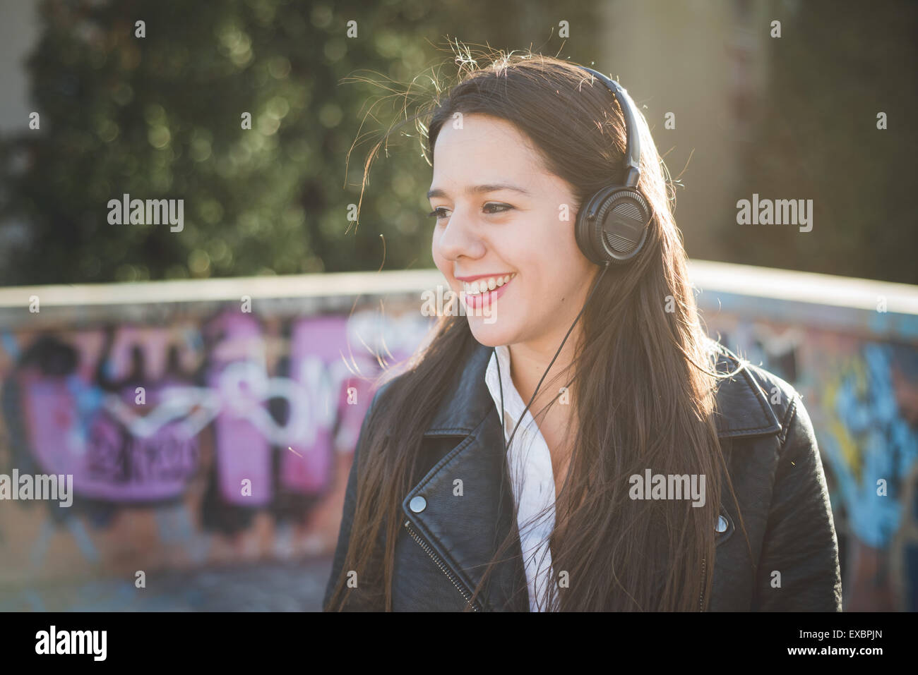 young beautiful long hair woman in town during sunset backlight ...