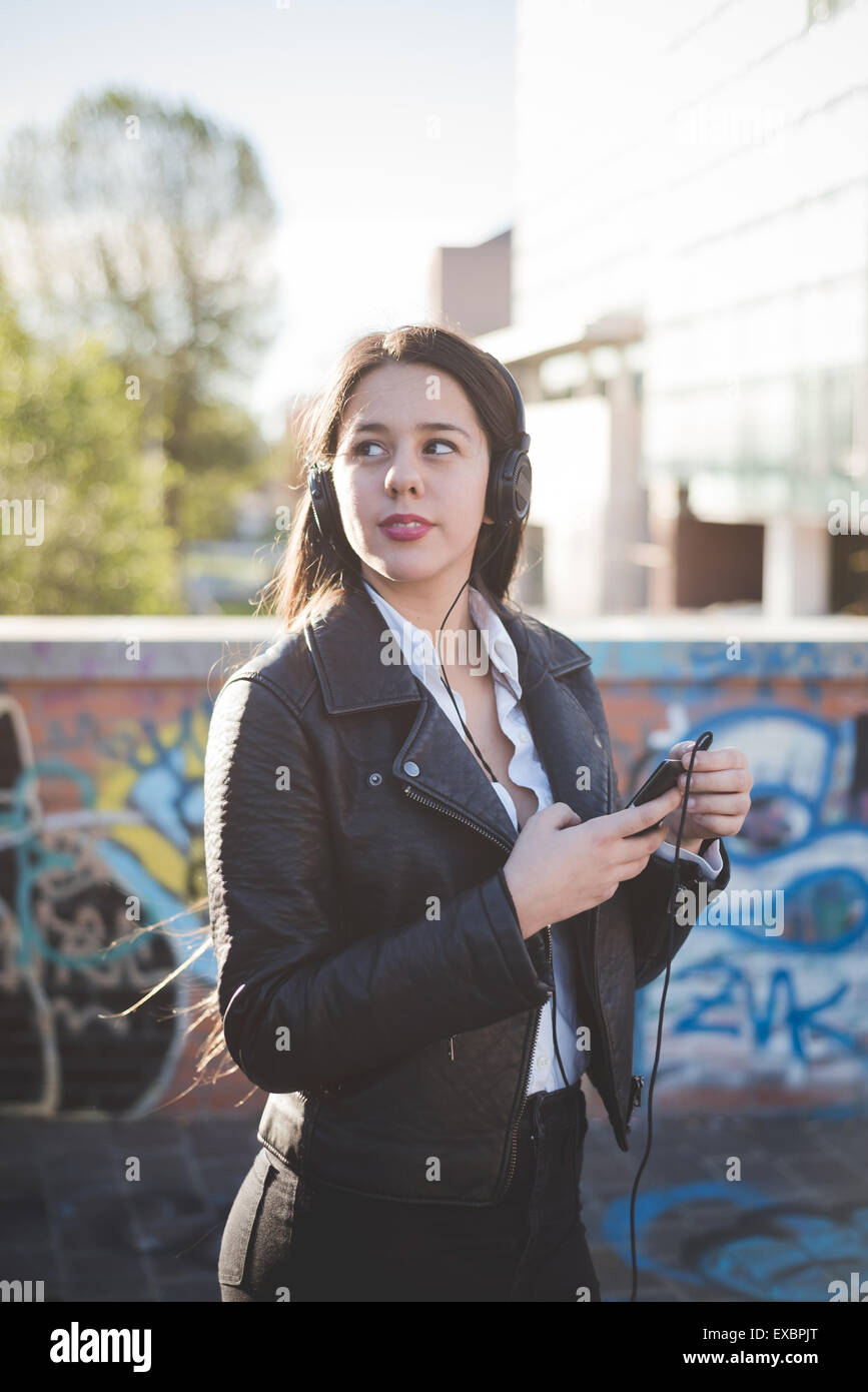 young beautiful long hair woman in town during sunset backlight ...
