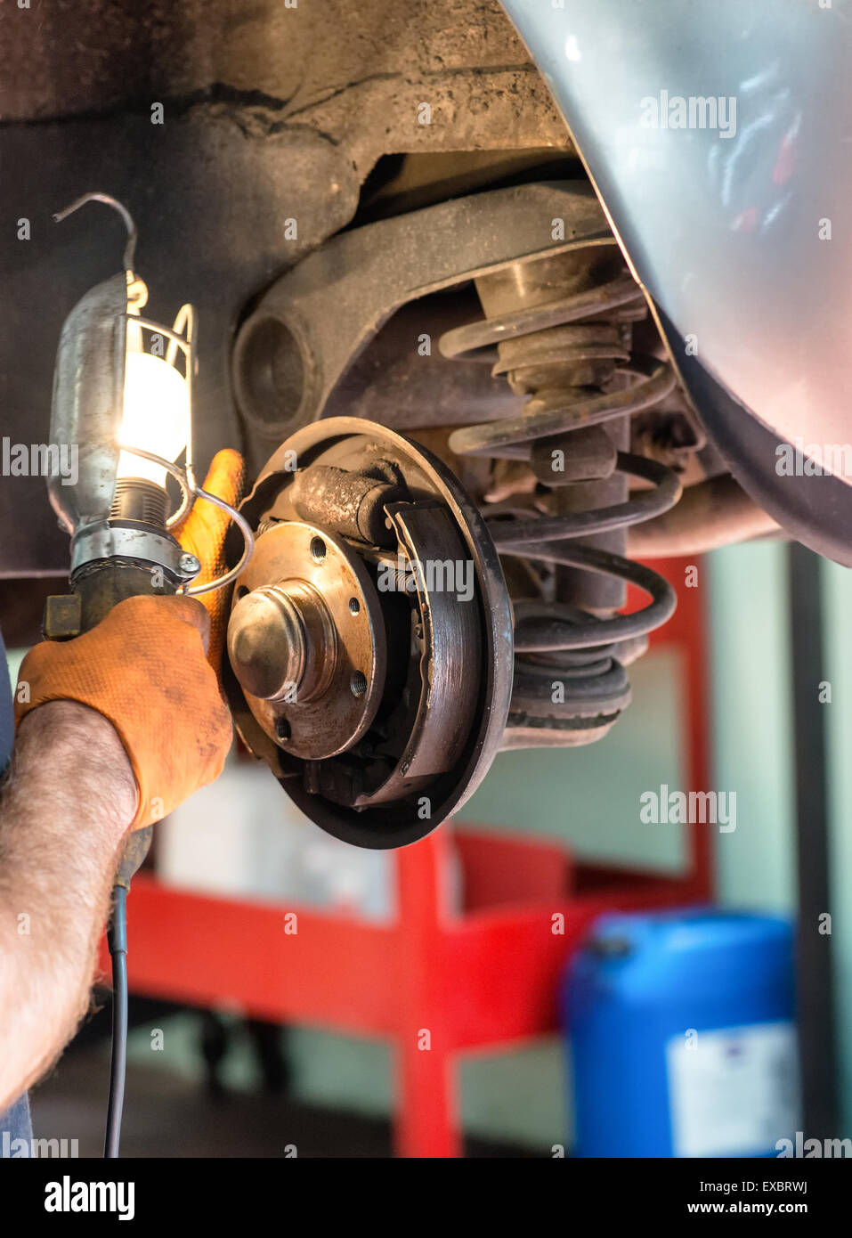Mechanic working on car brakes with a torch Stock Photo