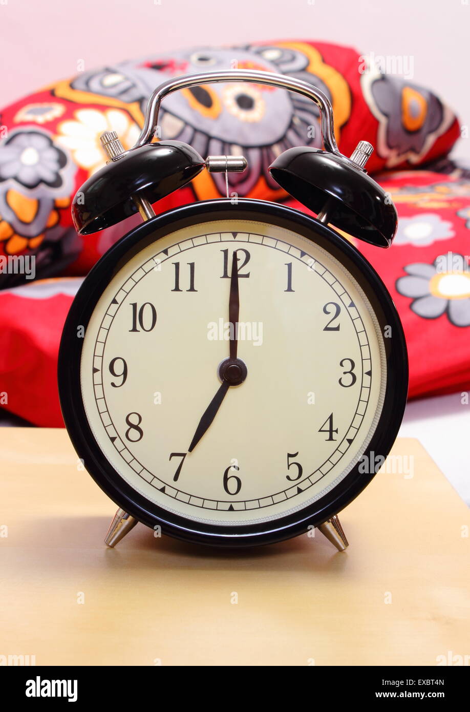 Ringing alarm clock set to 7am and empty bed in bedroom in background Stock  Photo - Alamy