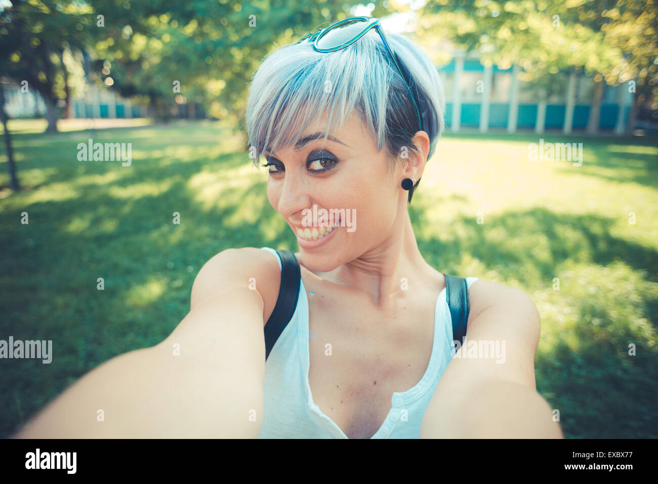 young-beautiful-short-blue-hair-hipster-woman-selfie-in-the-city-stock